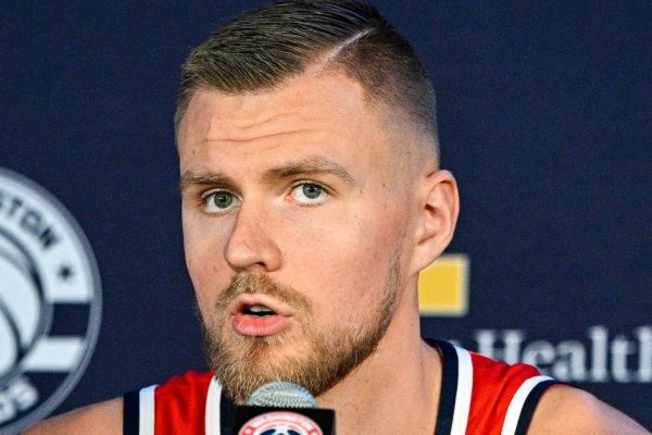 Kristaps Porzingis speaking at a press conference — the Warriors star is the subject of trade rumors as he battles POTS