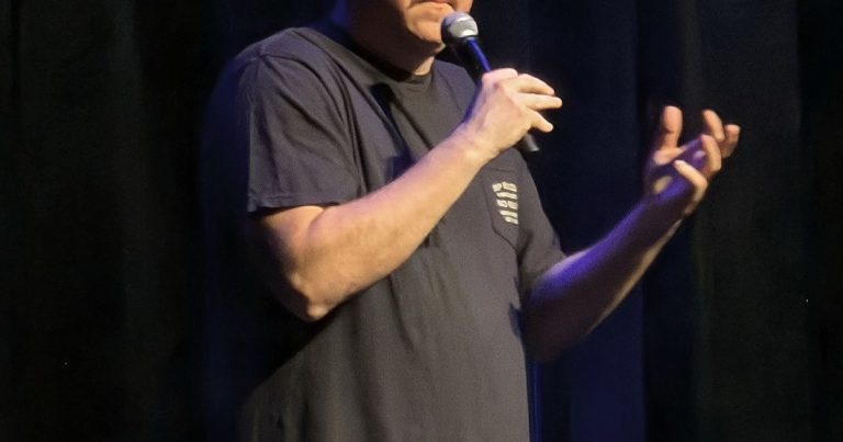 Shane Gillis performing stand-up comedy on stage
